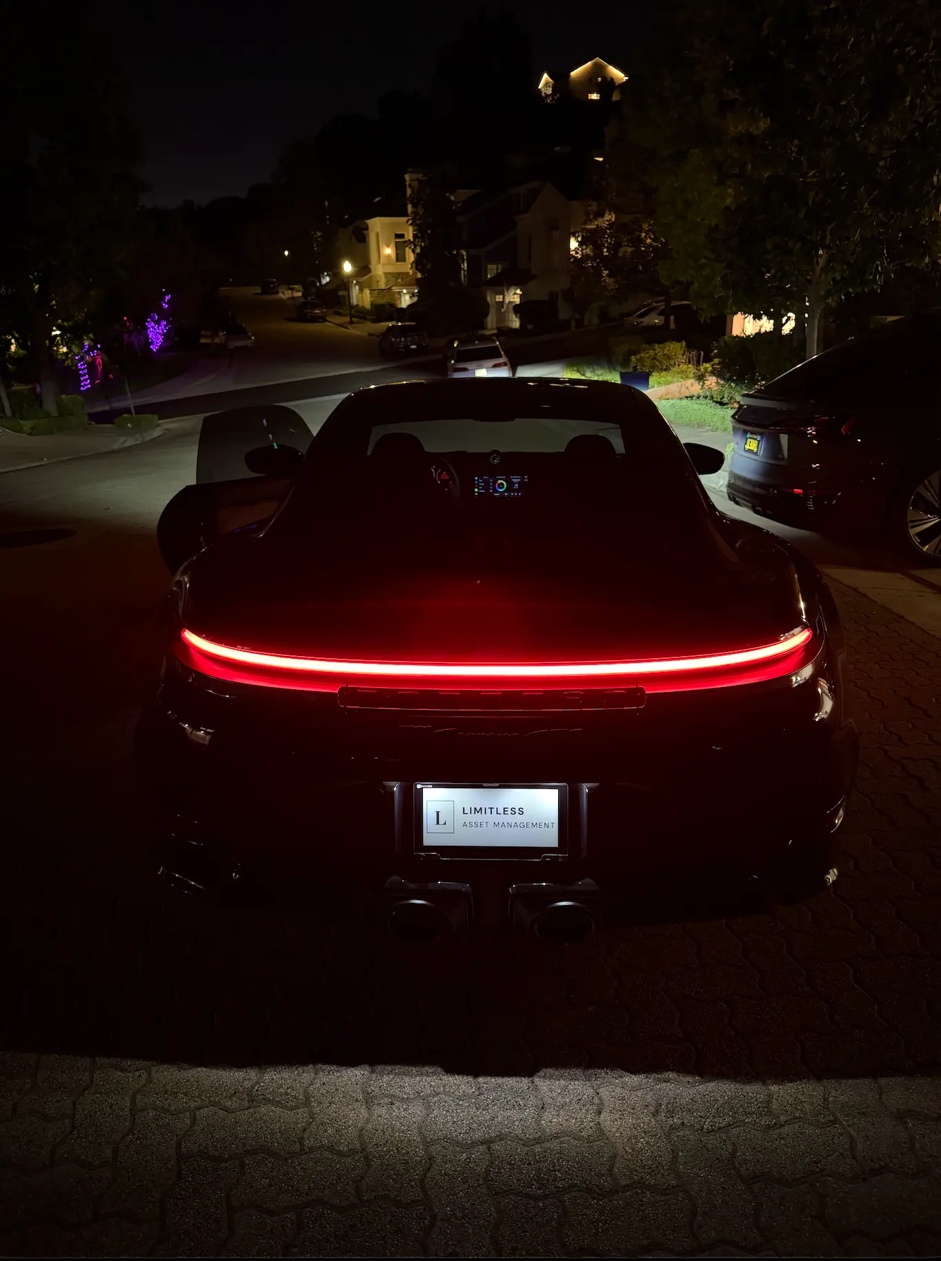 Black Porsche 911 at night with a LIMITLESS digital license plate