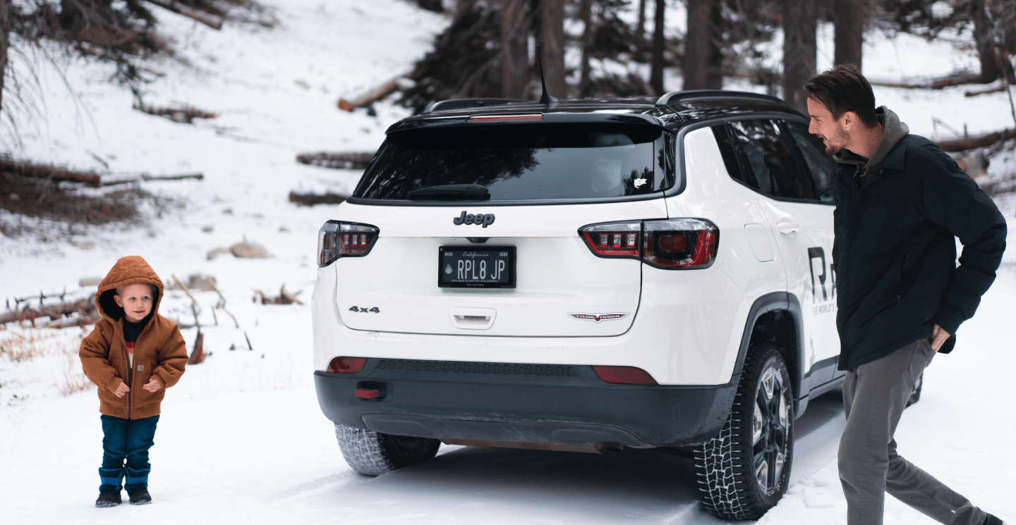 Family loading a snow-ready SUV wearing a Reviver RPlate